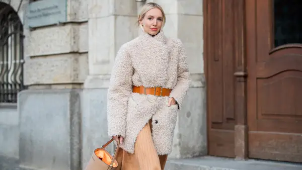 BERLIN, GERMANY - JANUARY 14: Leonie Hanne wearing total look Marc Cain: beige teddy coat, orange brown belt, pleated skirt, brown boots and bucket bag seen during the Berlin Fashion Week Autumn/Winter 2020 on January 14, 2020 in Berlin, Germany. (Photo by Christian Vierig/Getty Images)