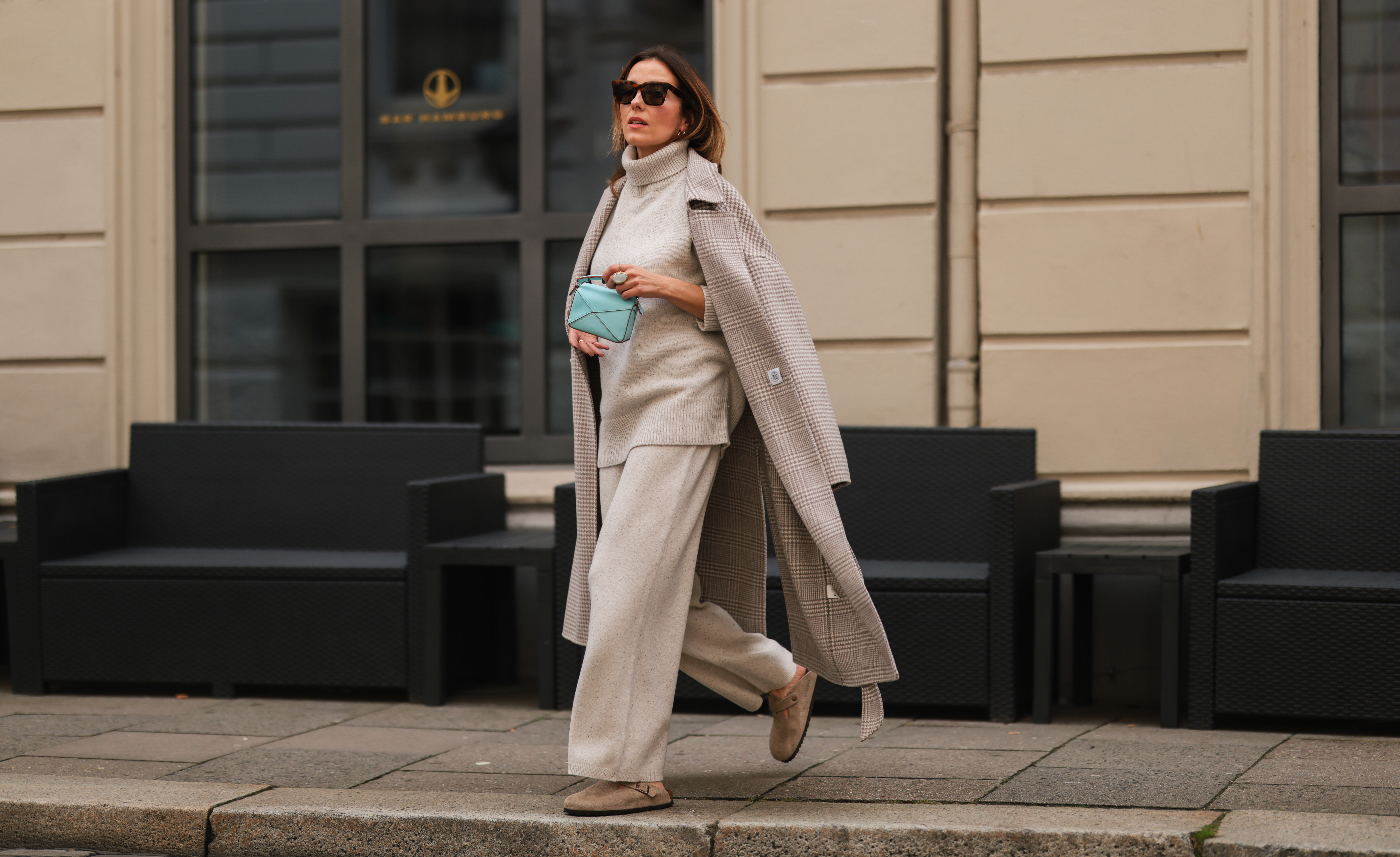 Elise Soho wearing Birkenstock beige sandals, Joseph beige two piece, Nanushka beige coat, Loewe mini blue baby bag on August 30, 2021 in Hamburg, Germany.