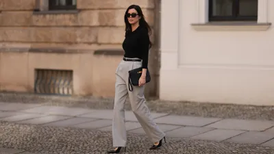 Leo Eberlin seen wearing Bottega Veneta black sunglasses, Leo Mathild jewelry / diamond bracelet and rings, Allude x Leo Mathild cashmere wool knit buttoned body, Toteme black leather belt, Velaa light grey elegant suit pants, Hermès black leather clutch bag and Saint Laurent black varnished leather heels / pumps, on February 25, 2024 in Berlin, Germany.