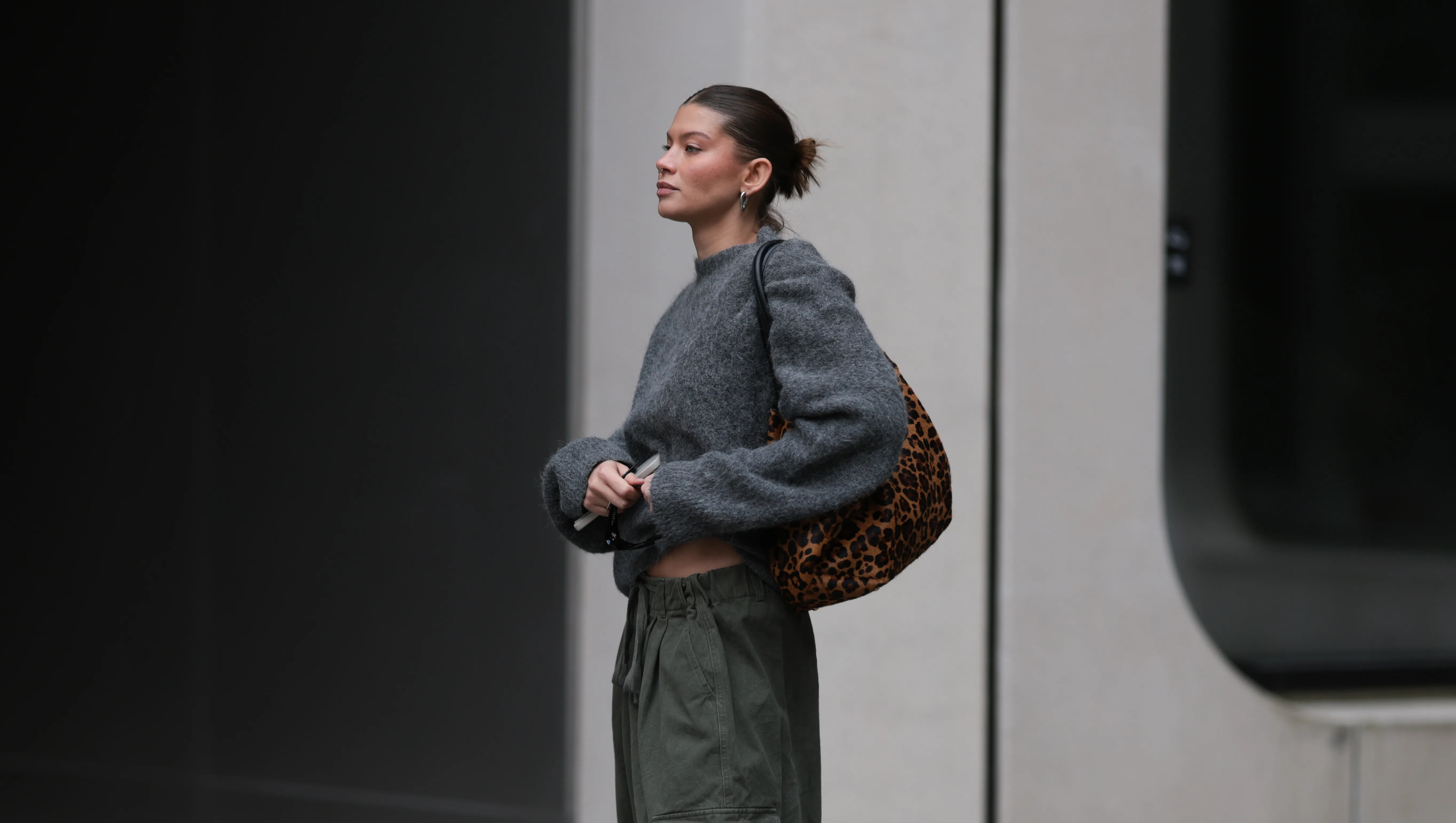BERLIN, GERMANY - OCTOBER 17: Sophia Geiss with a brown haired sleek bun seen wearing a grey oversized LeGer sweater styled with khaki Frankie Shop cargo wide pants, black LeGer boots, and Mango rectangular sunglasses, carrying a leopard-print DeMellier Leo bag on October 17, 2025 in Berlin, Germany. (Photo by Jeremy Moeller/Getty Images)