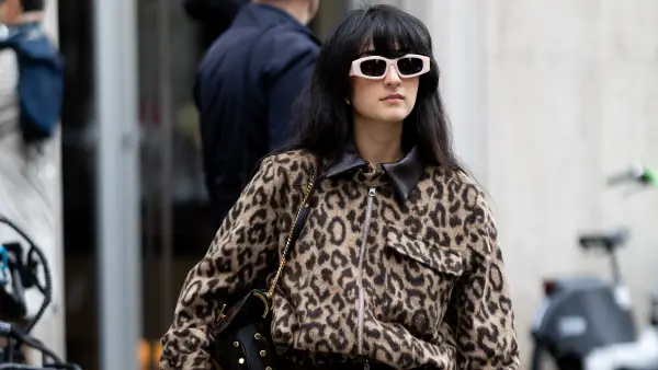 MILAN, ITALY - SEPTEMBER 27: A guest wears brown trousers, beige sunglasses, a leopard printed cargo cropped jacket, a brown silk skirt and a black leather bag outside Dolce & Gabbana show during the Milan Fashion Week Womenswear Spring/Summer 2026 on September 27, 2025 in Milan, Italy. (Photo by Valentina Frugiuele/Getty Images)