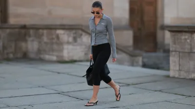 BERLIN, GERMANY - SEPTEMBER 06: Sophia Geiss seen wearing Vehla Eyewear narrow oval-shaped black sunglasses with sleek frames, Miu Miu fitted heather-grey ribbed cardigan top featuring a pointed collar and button-down front, Mango high-waisted black cropped leggings, Demelier London large structured black tote bag with gold hardware, LeGer black thong-strap heeled sandals / heels, on September 06, 2025 in Berlin, Germany. (Photo by Jeremy Moeller/Getty Images)