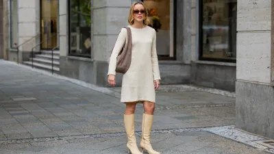 BERLIN, GERMANY - AUGUST 03: Tina Haase wears by Malene Birger butter yellow dress with long sleeves, beige Tony Bianco high knee boots, Liebeskind brown Suede shoulder bag, Le Specs sunglasses on August 03, 2025 in Berlin, Germany. (Photo by Christian Vierig/Getty Images)