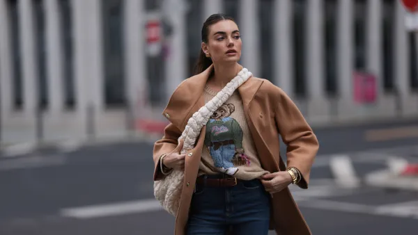 BERLIN, GERMANY - NOVEMBER 09: Celine Bethmann seen wearing gold earrings, Ralph Lauren beige wool teddy knit sweater, Liu Jo brown wool short coat, COS cream white crossbody bag, Zara blue denim jeans / pants, on November 09, 2023 in Berlin, Germany. (Photo by Jeremy Moeller/Getty Images)