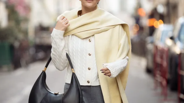 PARIS, FRANCE - MARCH 06: Gili Biegun wears grey pants, white knitted top with long sleeves, and pale yellow long wide scarf, balck leather bag during the Womenswear Fall/Winter 2025/2026 as part of Paris Fashion Week on March 06, 2025 in Paris, France. (Photo by Raimonda Kulikauskiene/Getty Images)