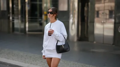 BERLIN, GERMANY - SEPTEMBER 1: Sophia Geiss is seen wearing a relaxed fit white sweatshirt with a slightly oversized cut; a white mini skirt that pairs with the sweatshirt from Black Palms; a structured black leather handbag carried by the top handle, with gold details from YSL; oversized, oval shaped black sunglasses from Mango; her brown hair is parted in the middle and pulled back into a low, messy bun on September 1, 2025 in Berlin, Germany. (Photo by Moritz Scholz/Getty Images)