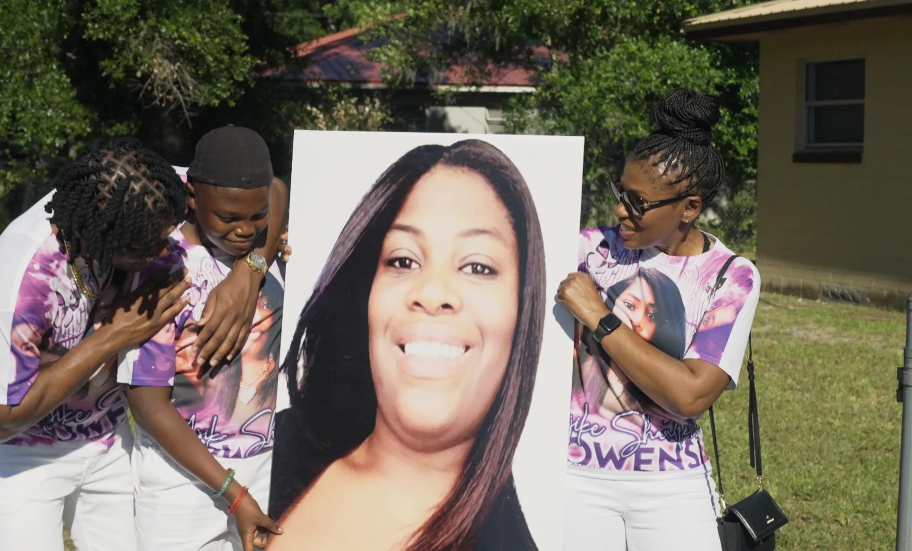 A group of people hold up a poster in The Perfect Neighbor