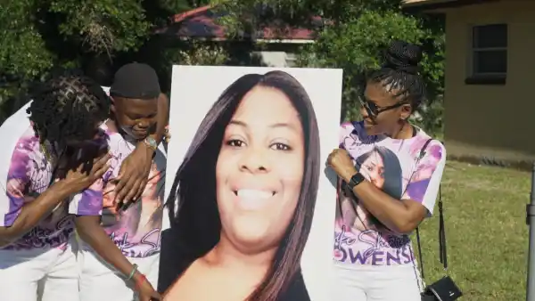 A group of people hold up a poster in The Perfect Neighbor