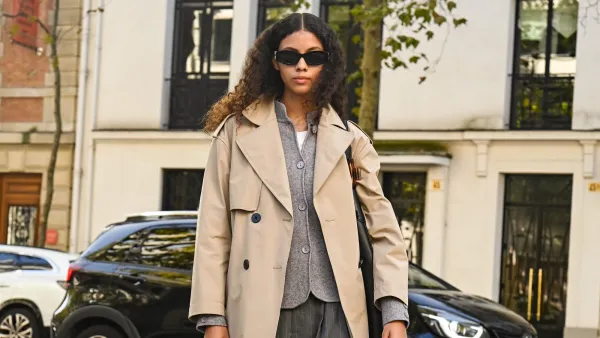 PARIS, FRANCE - OCTOBER 05: Model Nazarit Machin is seen wearing a tan trench coat, gray cardigan, gray pants, shoes and black sunglasses with black bag outside the Lacoste show during the Womenswear Spring Summer 2026 as part of Paris Fashion Week on October 05, 2025 in Paris, France. (Photo by Daniel Zuchnik/Getty Images)