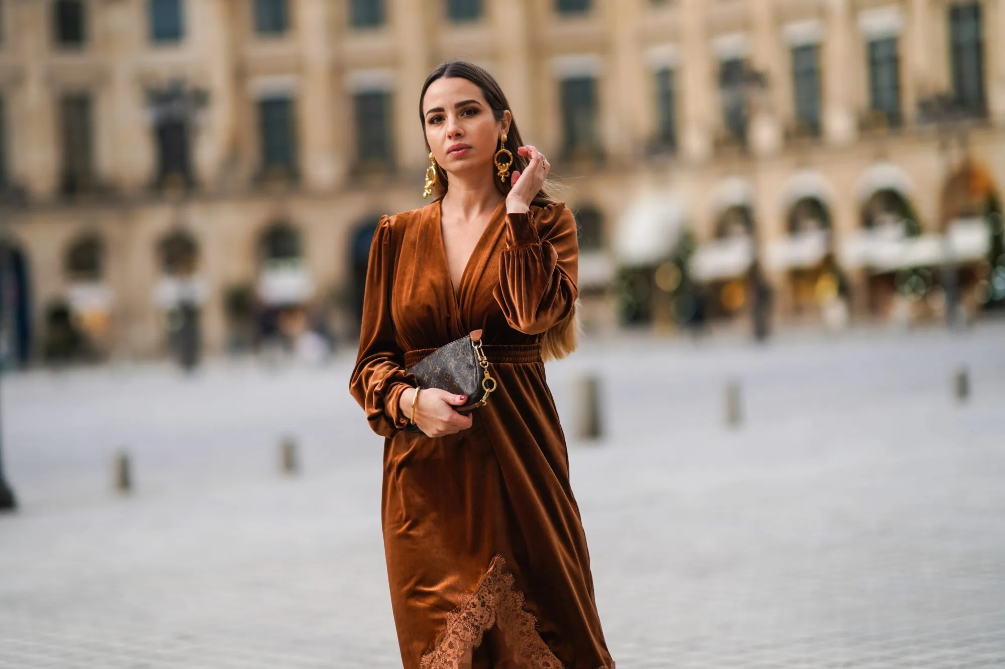 PARIS, FRANCE - DECEMBER 04: Maria Rosaria Rizzo wears golden long earrings from Raspini, a brown fluffy long winter coat from Max Mara, a brown leather monogram Vuitton bag, a brown velvet low-neck v-neck dress with lace and floral embroidery on the bottom part from Imprevu, on December 04, 2020 in Paris, France. (Photo by Edward Berthelot/Getty Images)