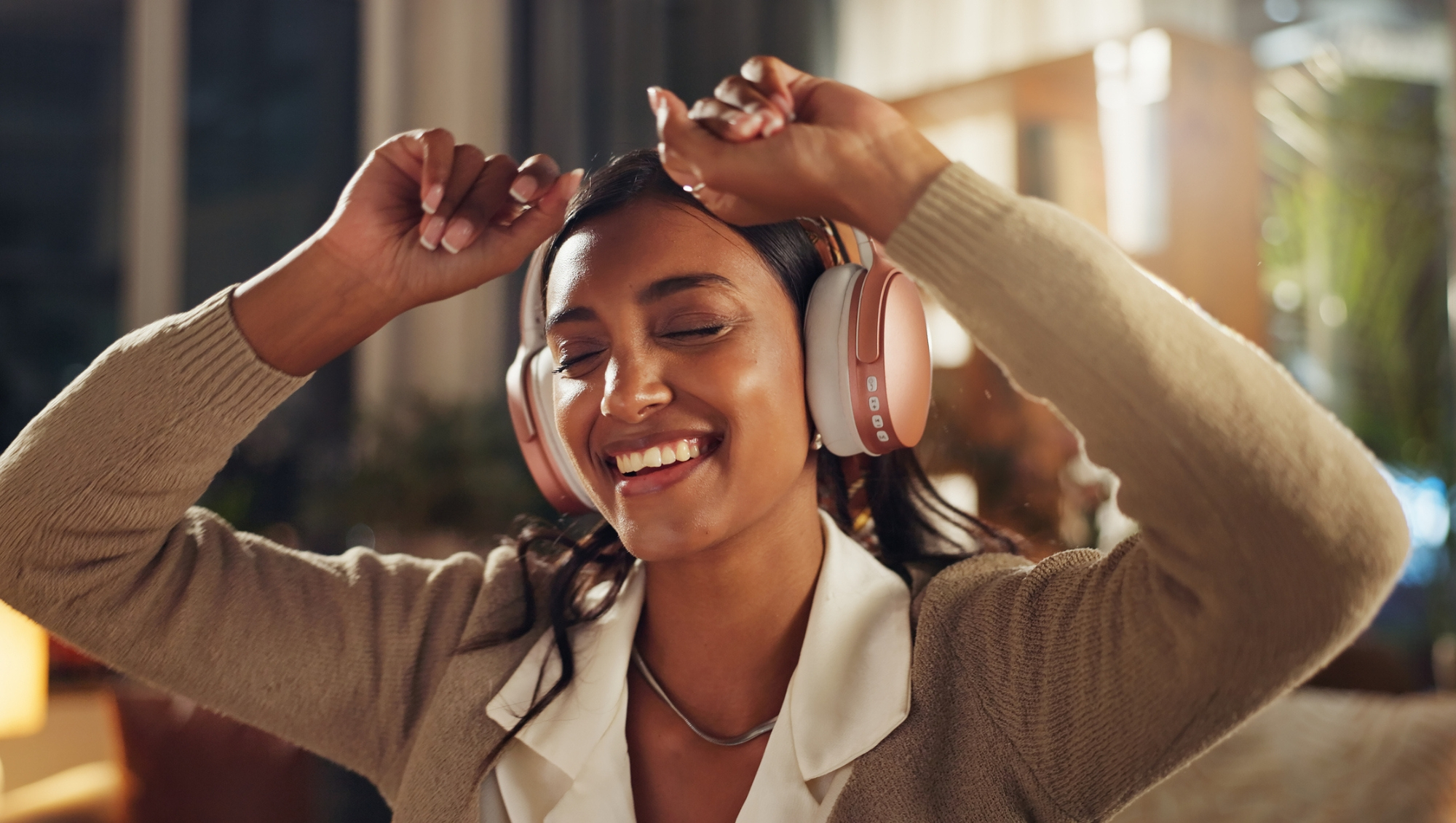 Woman dancing while wearing over-ear headphones similar to Apple AirPods Max during Black Friday sale.