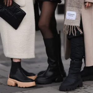 REYKJAVIK, ICELAND - NOVEMBER 15: Annabel Rosendahl (L) is seen wearing Copenhagen Studios CPH 276 Vitello black/ pale beige boots, Copenhagen Studios black clutch bag and Dorothee Schumacher creme white wool coat; Marie Hindkaer (M) is seen wearing a black Prada nylon bag, black leather Copenhagen Studios CPH145 boots, creme white Samsoe Samsoe knit sweater, Acne Studios black short skirt and a black Jw Anderson x Uniqlo jacket; Mie Juel (R) wears Copenhagen Studios beige wool scarf, Copenhagen Studios CPH149 black boots, Birgitte Herskind beige wool coat and black Basic Apparel pants, on November 15, 2022 in Reykjavik, Iceland. (Photo by Jeremy Moeller/Getty Images for Copenhagen Studios)