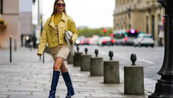 PARIS, FRANCE - SEPTEMBER 28: Natalia Verza wears sunglasses, a Fendi full outfit made of a yellow padded silky jacket, a Fendi leather monogram bag, a beige padded dress with yellow ruffled mesh upper part, blue leather Fendi long boots, on September 28, 2020 in Paris, France. (Photo by Edward Berthelot/Getty Images)