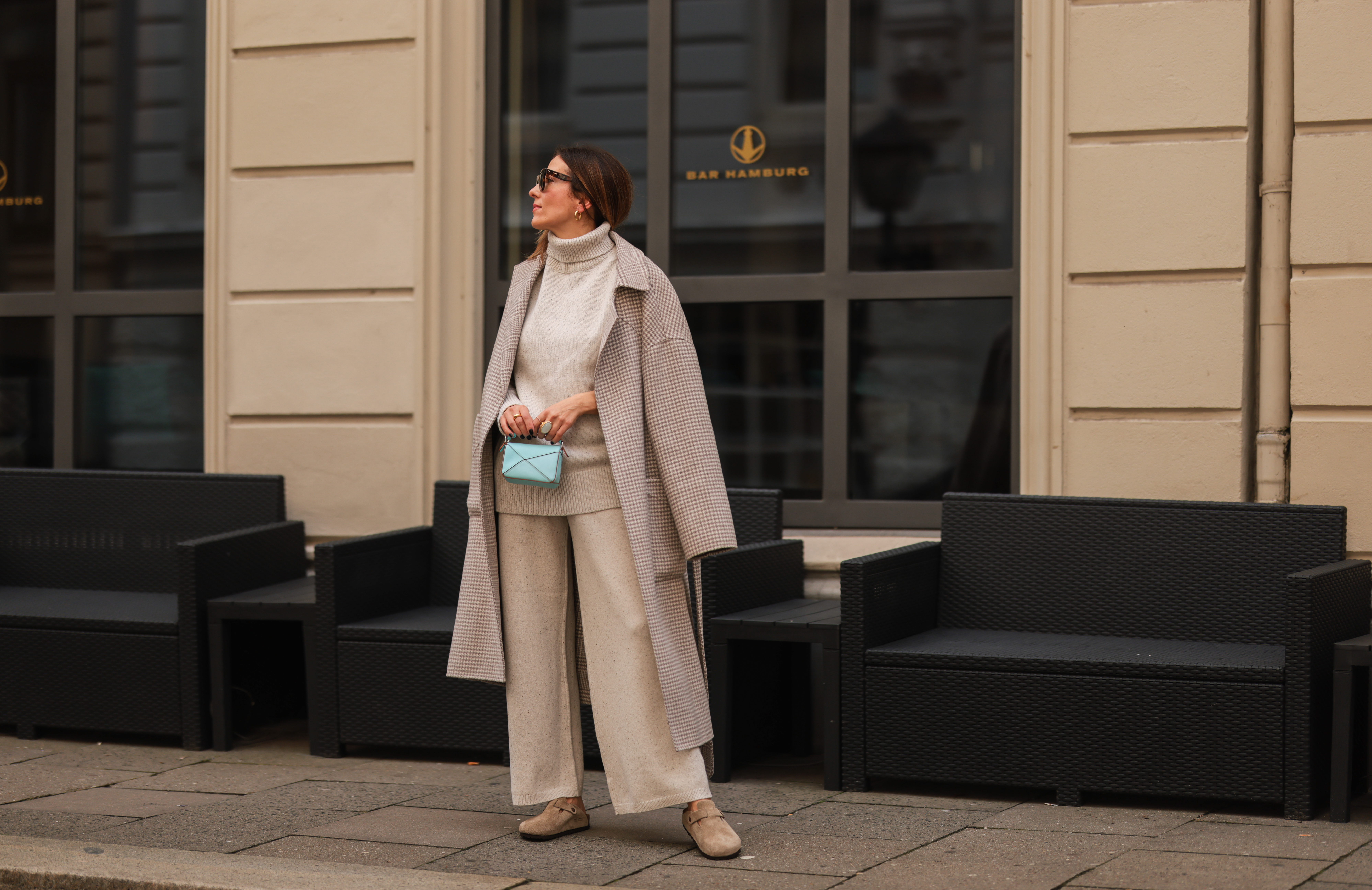 Elise Soho wearing Birkenstock beige sandals, Joseph beige two piece, Nanushka beige coat, Loewe mini blue baby bag on August 30, 2021 in Hamburg, Germany.