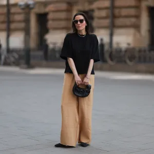 HAMBURG, GERMANY - MAY 09: Elise Seitz seen wearing a Bottega Veneta Jodie black leather bag, Isabel Marant black boots, Soho Studios black shirt and beige and brown pants and Ace and Tate black shades on May 09, 2023 in Hamburg, Germany. (Photo by Jeremy Moeller/Getty Images)