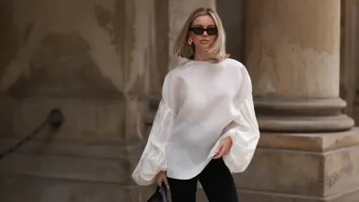 HAMBURG, GERMANY - APRIL 05: Isabelle Hartmann seen wearing Vehla Eyewear black / brown sunglasses, Nootka gold earrings, Khaite oversized puffy ruffled long sleeve silk top, Isabelle Hartmann x Edited black slit pants and Toteme black leather bag on April 05, 2024 in Hamburg, Germany. (Photo by Jeremy Moeller/Getty Images)
