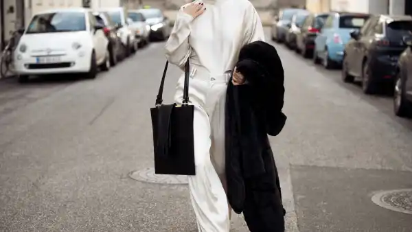 Gili Biegun wears silk cream long trousers and matching top with neck detail by Aeron, black leather square bag by Aeron, long black leather gloves, extra large faux fur coat and Saint Laurent heels on December 03, 2024 in Copenhagen, Denmark.