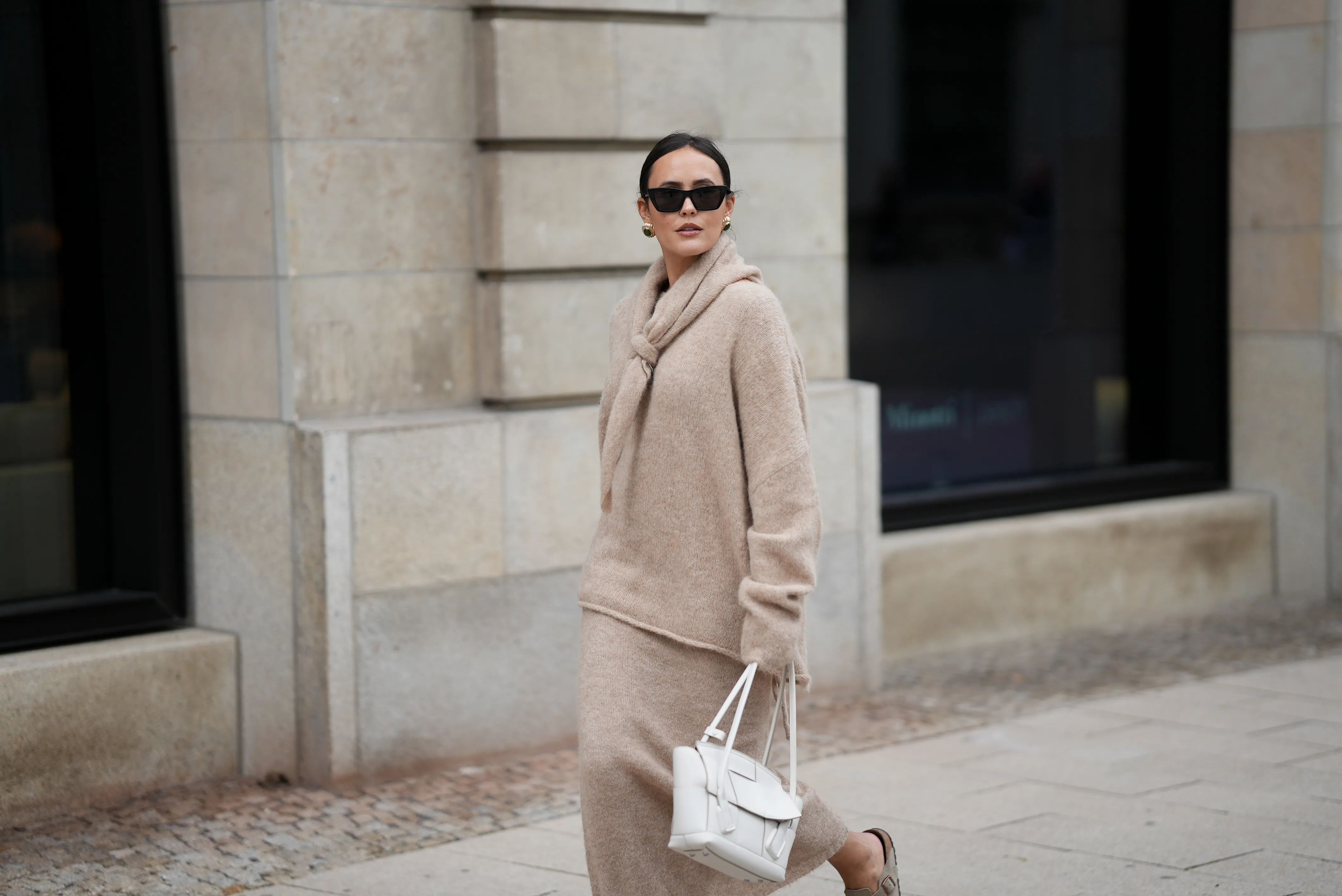 Laura Noltemeyer is seen wearing an oversized beige alpaca wool sweater with tie-back detailing by Aylin K&ouml;nig; a long alpaca wool knit skirt in a straight cut by Aylin K&ouml;nig; an alpaca knit scarf draped and knotted around the neck by Aylin K&ouml;nig; a white intrecciato leather handbag called &bdquo;Arco Bag&ldquo; by Bottega Veneta; slim black cat-eye sunglasses by Yves Saint Laurent; gold statement earrings with a green stone detail by Mango; her brown and straight hair is tied in a low ponytail on October 16, 2025 in Hamburg, Germany.