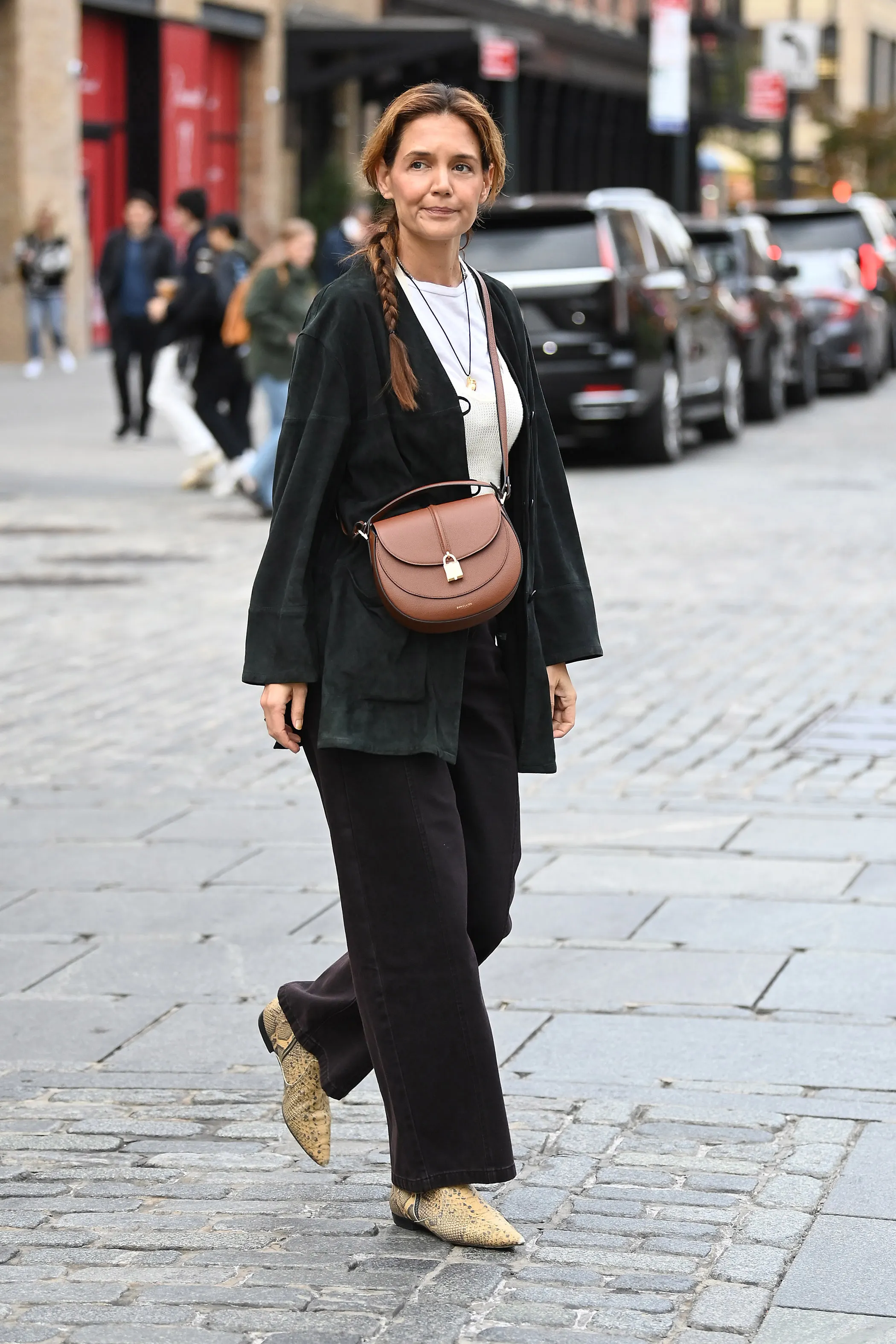 Katie Holmes spotted with her hair in a long braid and wearing a DeMellier bag on October 29, 2025 in New York City.