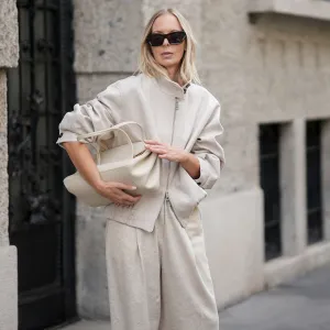 MILAN, ITALY - SEPTEMBER 25: Mirja Klein is seen wearing a beige wool zip-up bomber jacket with a high collar and elastic waistband by Liviana Conti; beige wide-leg wool trousers in a relaxed silhouette by Liviana Conti; an off-white structured leather handbag with top handles and a flap top by Liviana Conti; rectangular black sunglasses with a glossy acetate frame by Loewe; her blond hair is worn loose with a middle parting on September 25, 2025 in Milan, Italy. (Photo by Moritz Scholz/Getty Images)