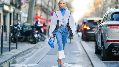 PARIS, FRANCE - JANUARY 22: Leonie Hanne wears earrings, a blue turtleneck, a white oversized V-neck knit jacket with grey inserts, a blue Prada handbag, blue crop jeans with white hem, blue pointy heeled pumps, outside Viktor & Rolf, during Paris Fashion Week - Haute Couture Spring/Summer 2020, on January 22, 2020 in Paris, France. (Photo by Edward Berthelot/Getty Images )