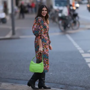 HAMBURG, GERMANY - DECEMBER 09: Anna Wolfers seen wearing a flower patterned dress with puffed sleeves, a neon green bag and black cowboy boots on December 09, 2022 in Hamburg, Germany. (Photo by Jeremy Moeller/Getty Images)