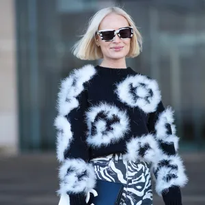 COPENHAGEN, DENMARK - JANUARY 31: Thora Valdimars wears a black and white full look, sunglasses, a floral print fluffy pullover , striped zebra print pants,, a Chanel bi-color clutch, outside OperaSport, during the Copenhagen Fashion Week AW24 on January 31, 2024 in Copenhagen, Denmark. (Photo by Edward Berthelot/Getty Images)