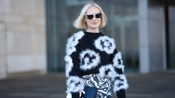 COPENHAGEN, DENMARK - JANUARY 31: Thora Valdimars wears a black and white full look, sunglasses, a floral print fluffy pullover , striped zebra print pants,, a Chanel bi-color clutch, outside OperaSport, during the Copenhagen Fashion Week AW24 on January 31, 2024 in Copenhagen, Denmark. (Photo by Edward Berthelot/Getty Images)