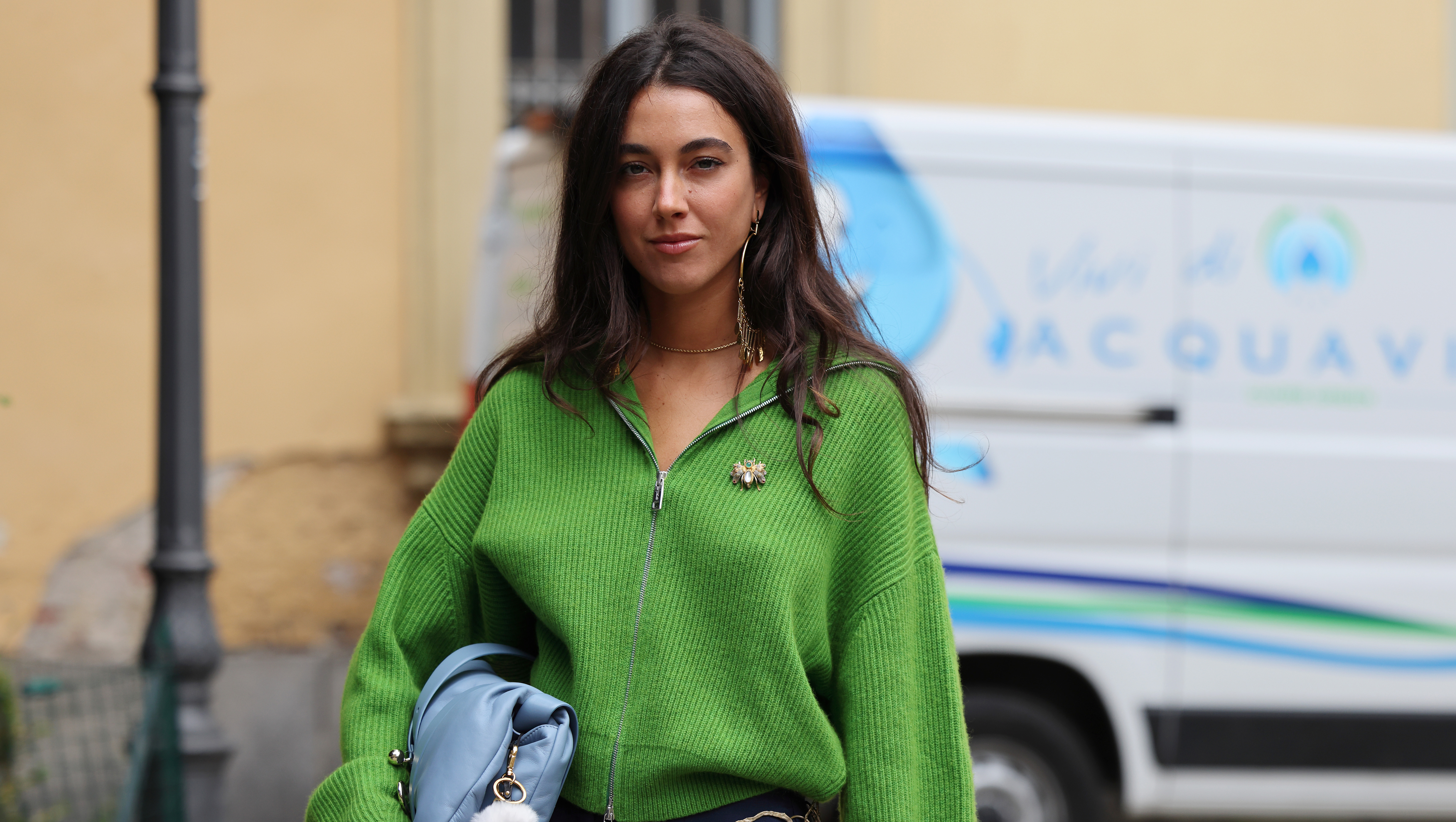 MILAN, ITALY - SEPTEMBER 20: A guest wears green jumper, blue shorts, light blue bag, outside Sportmax, during the Milan Fashion Week Womenswear Spring/Summer 2025 on September 20, 2024 in Milan, Italy. (Photo by Claudio Lavenia/Getty Images)