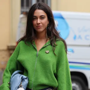 MILAN, ITALY - SEPTEMBER 20: A guest wears green jumper, blue shorts, light blue bag, outside Sportmax, during the Milan Fashion Week Womenswear Spring/Summer 2025 on September 20, 2024 in Milan, Italy. (Photo by Claudio Lavenia/Getty Images)
