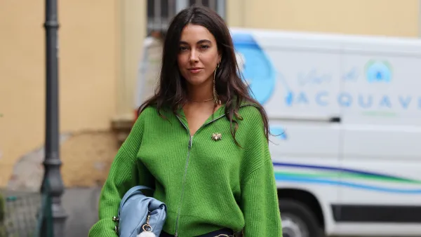 MILAN, ITALY - SEPTEMBER 20: A guest wears green jumper, blue shorts, light blue bag, outside Sportmax, during the Milan Fashion Week Womenswear Spring/Summer 2025 on September 20, 2024 in Milan, Italy. (Photo by Claudio Lavenia/Getty Images)