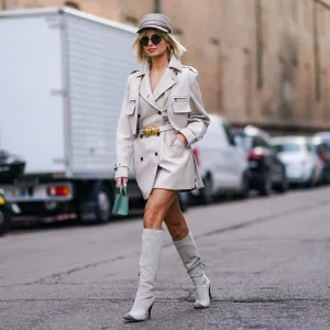 MILAN, ITALY - FEBRUARY 20: Xenia Adonts wears a white cap, a blazer jacket/dress, a belt with a golden part, a green bag, gray high boots, outside Max Mara, during Milan Fashion Week Fall/Winter 2020-2021 on February 20, 2020 in Milan, Italy. (Photo by Edward Berthelot/Getty Images)