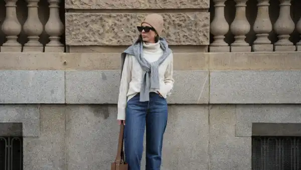 DUESSELDORF, GERMANY - NOVEMBER 10: Patricia Wirschke is seen wearing a cream cable-knit turtleneck sweater by Tommy Hilfiger; a light grey cable-knit sweater draped over her shoulders by Tommy Hilfiger; straight-leg blue jeans by Levi’s; brown suede boots with a pointed toe by Massimo Dutti; a brown suede tote bag with a shoulder strap by Max Mara; black cat-eye sunglasses by Phoebe Philo; a beige ribbed beanie with an embroidered crest logo by Tommy Hilfiger; her brown hair is worn straight and tucked into the collar; gold “Serpenti” earrings by Bulgari on November 10, 2025 in Duesseldorf, Germany. (Photo by Moritz Scholz/Getty Images)
