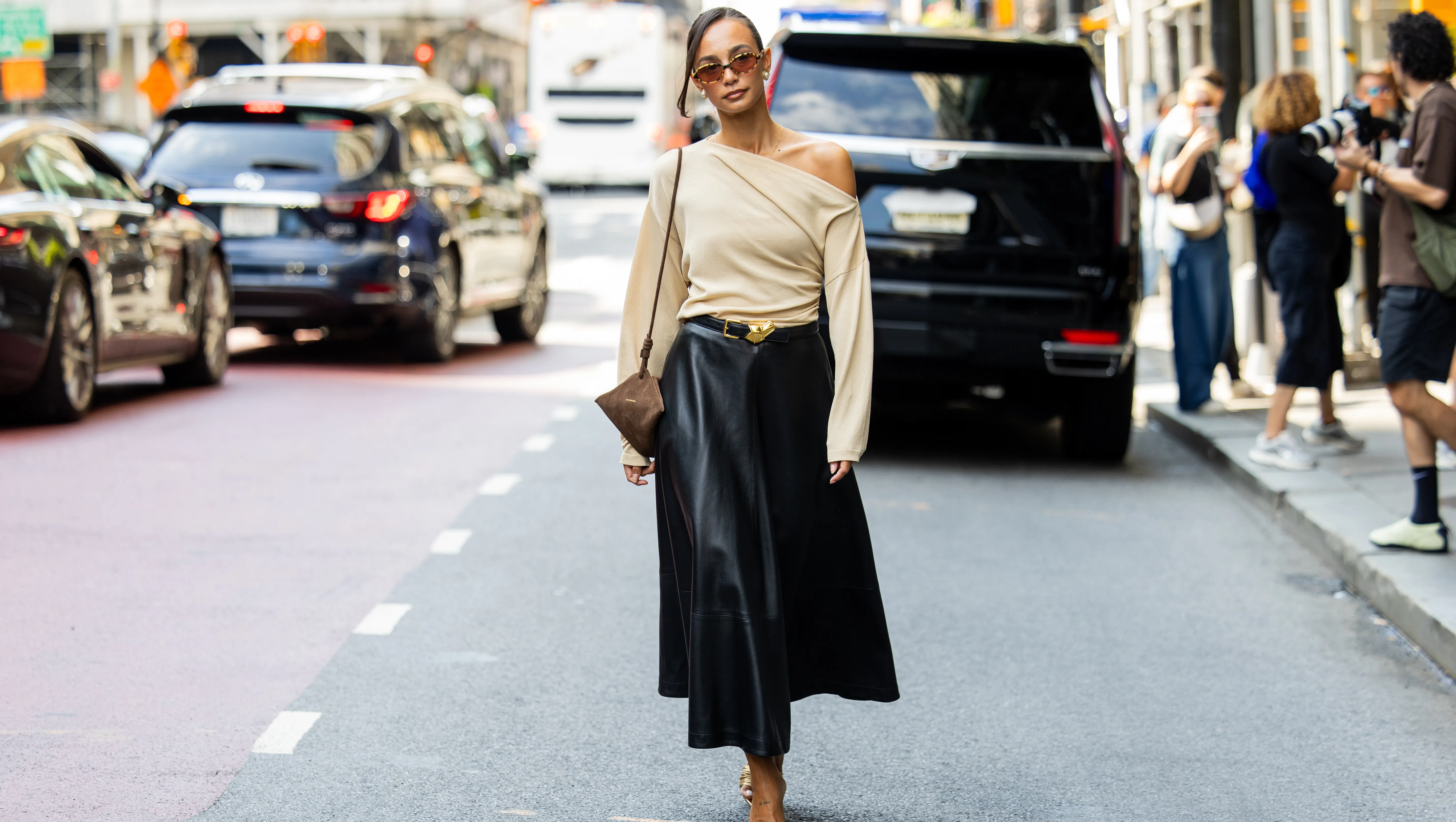NEW YORK, NEW YORK - SEPTEMBER 13: Blanca Arimany wears beige asymmetric top, black leather skirt, brown suede bag, heels, sunglass outside Altuzarra during New York Fashion Week on September 13, 2025 in New York City. (Photo by Christian Vierig/Getty Images)