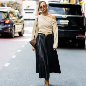 NEW YORK, NEW YORK - SEPTEMBER 13: Blanca Arimany wears beige asymmetric top, black leather skirt, brown suede bag, heels, sunglass outside Altuzarra during New York Fashion Week on September 13, 2025 in New York City. (Photo by Christian Vierig/Getty Images)