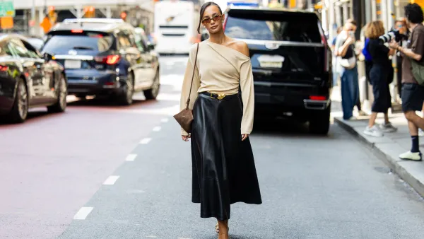 NEW YORK, NEW YORK - SEPTEMBER 13: Blanca Arimany wears beige asymmetric top, black leather skirt, brown suede bag, heels, sunglass outside Altuzarra during New York Fashion Week on September 13, 2025 in New York City. (Photo by Christian Vierig/Getty Images)