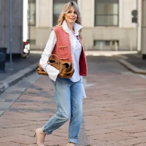 MILAN, ITALY - SEPTEMBER 28: Ekaterina Mamaeva wears white shirt Anna Quan, red vest Chanel, jeans Saint Laurent, rose ankle boots Acne Studios, brown bag Khaite during the Milan Fashion Week Womenswear Spring/Summer 2026 on September 28, 2025 in Milan, Italy. (Photo by Christian Vierig/Getty Images)