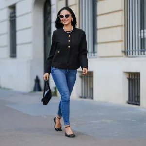 PARIS, FRANCE - JANUARY 07: Patricia Gloria Conteras wears black and white sunglasses, silver Chanel earrings, a pearl necklace, a black jacket with gold buttons, blue denim jeans / pants, a black leather bag, black leather ballerinas shoes, during a street style fashion photo session, on January 07, 2025 in Paris, France. (Photo by Edward Berthelot/Getty Images)