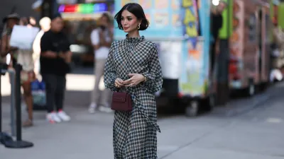 NEW YORK, NEW YORK - SEPTEMBER 12: Heart Evangelista is seen wearing golden earrings, a white/black/brown houndstooth patterned nigh neck midi dress with puffy long-sleeves, a golden watch, several rings in silver and gold, a purple leather bag from Carolina Herrera and plateau ankle boots in golden suede with floral print and chunky silber heels outside before the Carolina Herrera Spring Summer 2024 Runway Show on September 12, 2023 in New York City. (Photo by Jeremy Moeller/Getty Images)