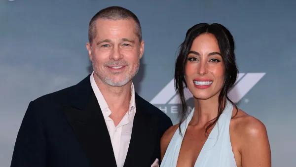 Brad Pitt and Ines de Ramon smiling together on the "F1" premiere red carpet.