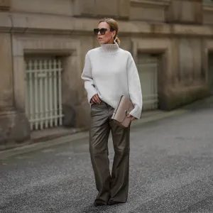 HAMBURG, GERMANY - SEPTEMBER 19: Alexandra Siedschlag is seen wearing a relaxed, high-collar ivory cashmere pullover with a soft ribbed texture from & Other Stories; khaki brown nappa sheepskin leather trousers with decorative stitching and wide leg silhouette from Bonprix; pointed dark brown suede boots with stiletto heel from Arket; a structured taupe leather Milo shoulder bag with gold hardware from Sézane; golden mid sized hoop earrings from Sence Copenhagen; oversized square sunglasses with acetate frame, golden logo detail on the temples and gradient glasses from Fendi; her blonde hair is styled in a sleek bob on September 19, 2025 in Hamburg, Germany. (Photo by Moritz Scholz/Getty Images)