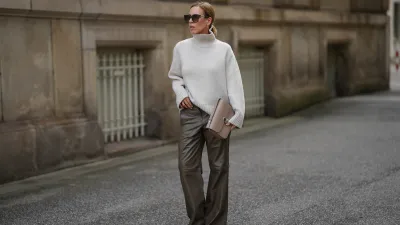 HAMBURG, GERMANY - SEPTEMBER 19: Alexandra Siedschlag is seen wearing a relaxed, high-collar ivory cashmere pullover with a soft ribbed texture from & Other Stories; khaki brown nappa sheepskin leather trousers with decorative stitching and wide leg silhouette from Bonprix; pointed dark brown suede boots with stiletto heel from Arket; a structured taupe leather Milo shoulder bag with gold hardware from Sézane; golden mid sized hoop earrings from Sence Copenhagen; oversized square sunglasses with acetate frame, golden logo detail on the temples and gradient glasses from Fendi; her blonde hair is styled in a sleek bob on September 19, 2025 in Hamburg, Germany. (Photo by Moritz Scholz/Getty Images)