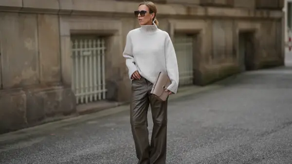 HAMBURG, GERMANY - SEPTEMBER 19: Alexandra Siedschlag is seen wearing a relaxed, high-collar ivory cashmere pullover with a soft ribbed texture from & Other Stories; khaki brown nappa sheepskin leather trousers with decorative stitching and wide leg silhouette from Bonprix; pointed dark brown suede boots with stiletto heel from Arket; a structured taupe leather Milo shoulder bag with gold hardware from Sézane; golden mid sized hoop earrings from Sence Copenhagen; oversized square sunglasses with acetate frame, golden logo detail on the temples and gradient glasses from Fendi; her blonde hair is styled in a sleek bob on September 19, 2025 in Hamburg, Germany. (Photo by Moritz Scholz/Getty Images)