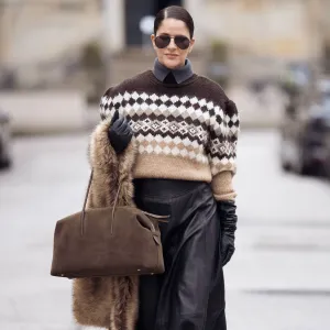 COPENHAGEN, DENMARK - DECEMBER 06: Gili Biegun wears maxi leather skirt, large Demellier London The Stockholm bag, brown Nordic holiday sweater, large brown fur scarf and black leather gloves on December 06, 2025 in Copenhagen, Denmark. (Photo by Raimonda Kulikauskiene/Getty Images)