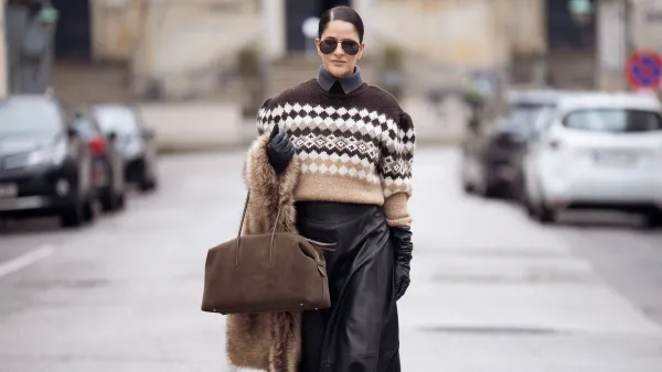 COPENHAGEN, DENMARK - DECEMBER 06: Gili Biegun wears maxi leather skirt, large Demellier London The Stockholm bag, brown Nordic holiday sweater, large brown fur scarf and black leather gloves on December 06, 2025 in Copenhagen, Denmark. (Photo by Raimonda Kulikauskiene/Getty Images)