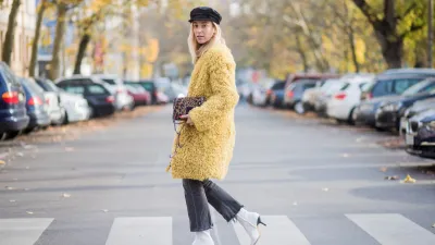 BERLIN, GERMANY - NOVEMBER 04: Sonia Lyson Jimmy Choo lockett petite bag hazelnut mix with leopard pony mix, shearling mustard coat Longchamp, black turtleneck & black Zara hat, dark grey skinny cropped flared jeans Citizens of Humanity, white H&M boots on November 4, 2017 in Berlin, Germany. (Photo by Christian Vierig/Getty Images)