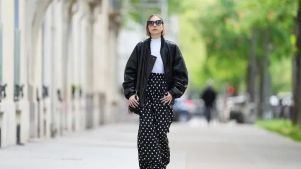 PARIS, FRANCE - APRIL 21: Emy Venturini wears Dite Eyewear Paris sunglasses, a white Intimissimi bodysuit, a black leather bomber jacket, black and white Balenciaga polka dots pants, a black leather Prada bag, golden Chloe rings, red leather Bottega Veneta shoes, during a street style fashion photo session, on April 21, 2024 in Paris, France. (Photo by Edward Berthelot/Getty Images)