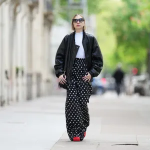 PARIS, FRANCE - APRIL 21: Emy Venturini wears Dite Eyewear Paris sunglasses, a white Intimissimi bodysuit, a black leather bomber jacket, black and white Balenciaga polka dots pants, a black leather Prada bag, golden Chloe rings, red leather Bottega Veneta shoes, during a street style fashion photo session, on April 21, 2024 in Paris, France. (Photo by Edward Berthelot/Getty Images)