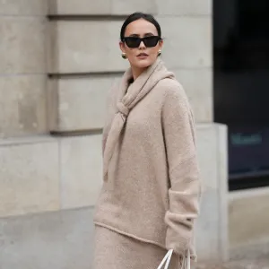 HAMBURG, GERMANY - OCTOBER 16: Laura Noltemeyer is seen wearing an oversized beige alpaca wool sweater with tie-back detailing by Aylin König; a long alpaca wool knit skirt in a straight cut by Aylin König; an alpaca knit scarf draped and knotted around the neck by Aylin König; a white intrecciato leather handbag called „Arco Bag“ by Bottega Veneta; slim black cat-eye sunglasses by Yves Saint Laurent; gold statement earrings with a green stone detail by Mango; her brown and straight hair is tied in a low ponytail on October 16, 2025 in Hamburg, Germany. (Photo by Moritz Scholz/Getty Images)