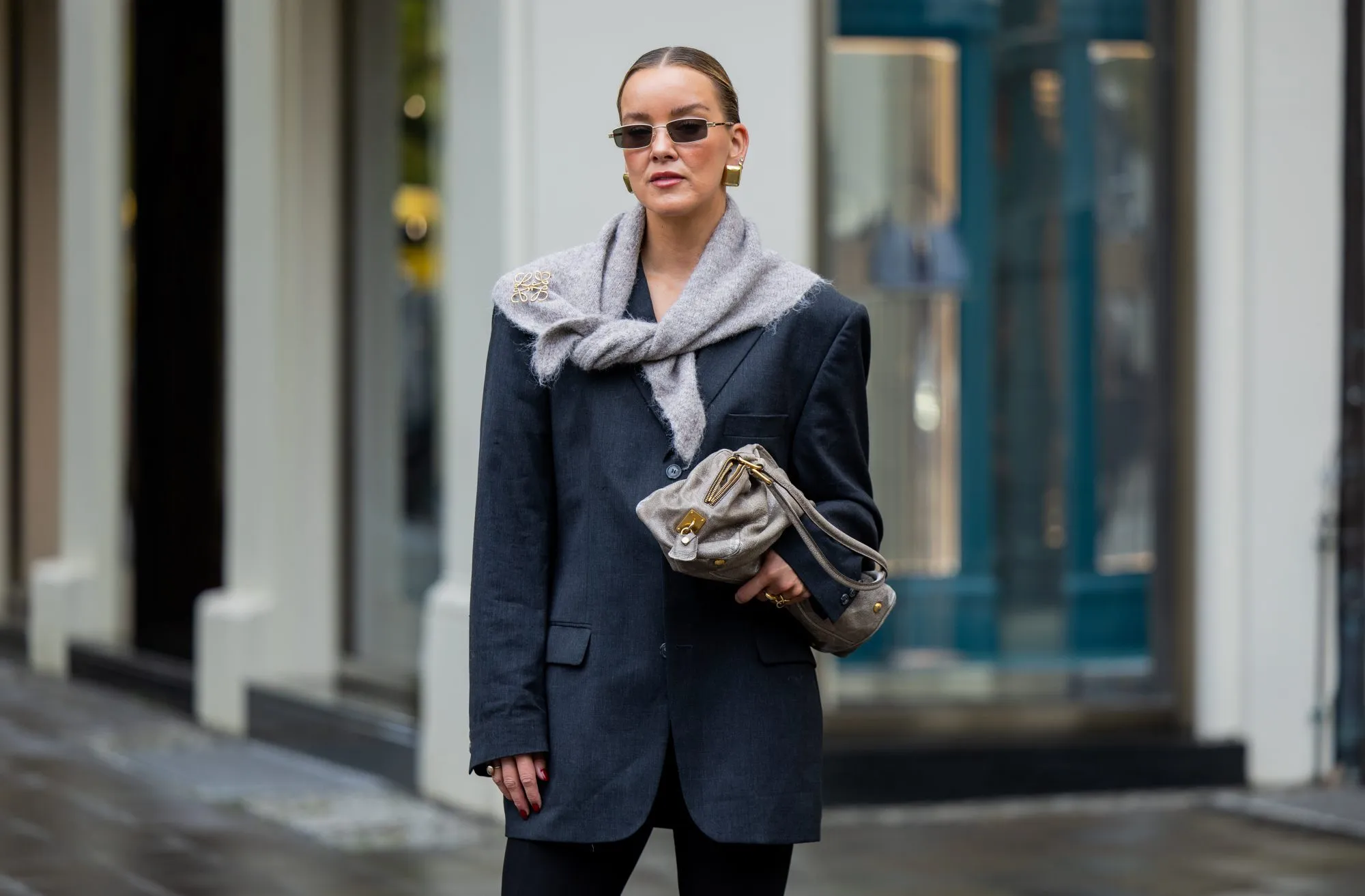 BERLIN, GERMANY - OCTOBER 08: Tina Haase wears vintage black oversize blazer, Black stirrup leggings, taupe knit triangle scarf Massimo Dutti, Loewe brooch, taupe grey Prada Bag on October 08, 2025 in Berlin, Germany. (Photo by Christian Vierig/Getty Images)